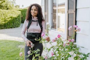  A woman using the Horizon back brace while pruning flowers.