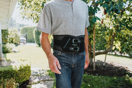 A man using the Horizon Pro backbrace in his garden.